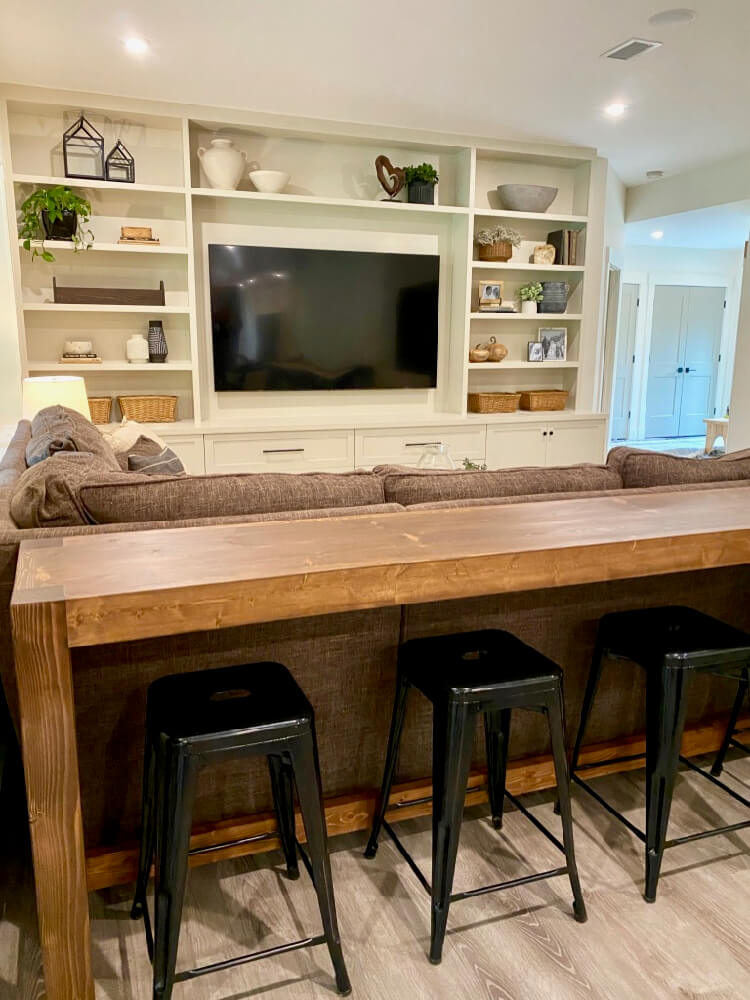 Console table and discount stools behind couch