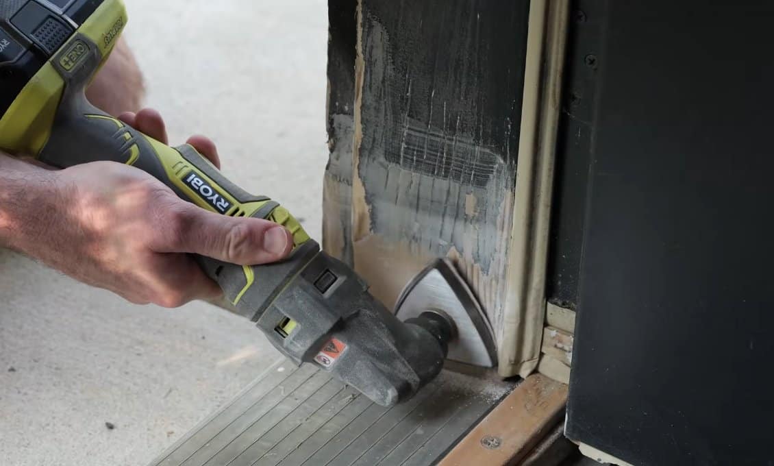 Detail-sanding the door frame repair with finer-grit sandpaper before priming