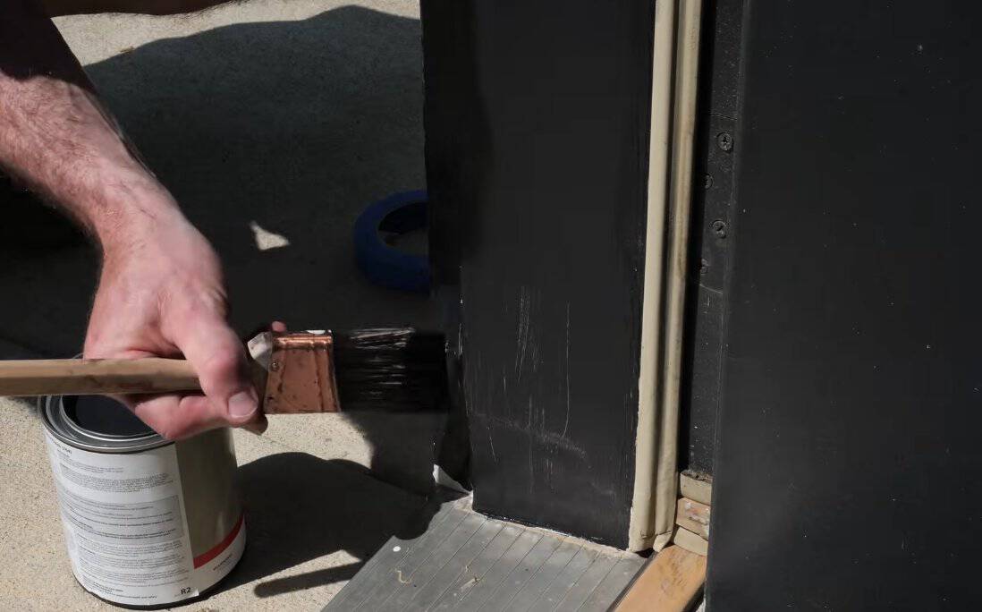 Painting the primed door frame with exterior trim paint to match the rest of the trim
