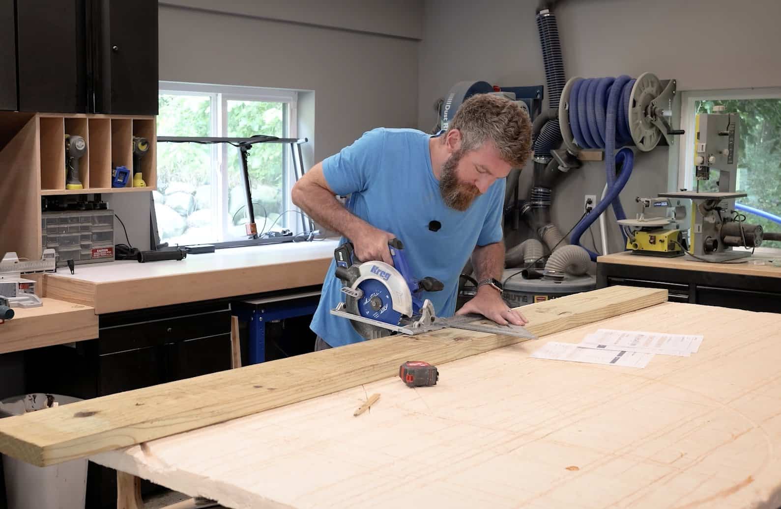 Crosscutting a 2x8 to length with a circular saw guided by a large speed square