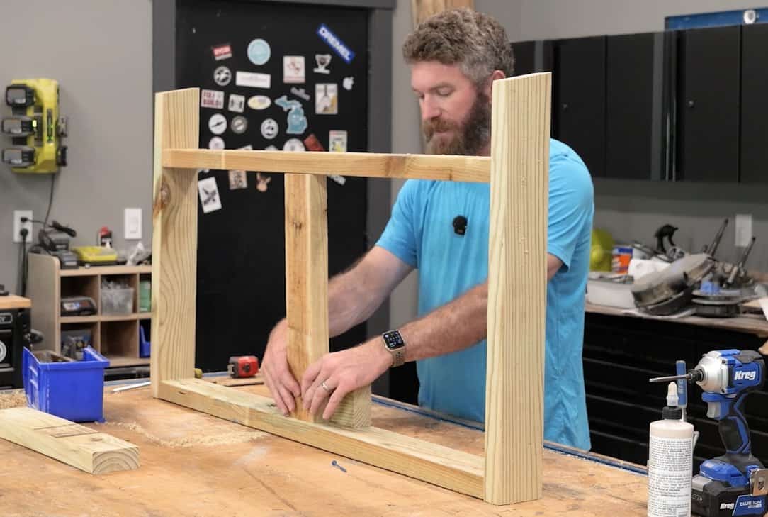 Setting the center support in the seat frame of a DIY outdoor loveseat with a spacer block