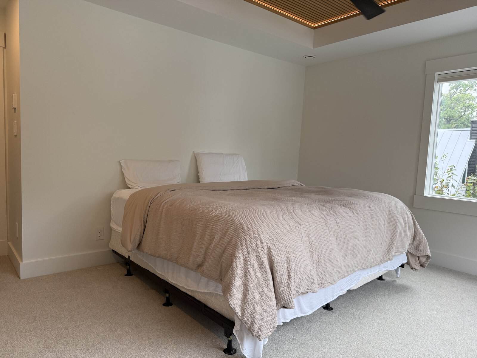 Mattress and box spring on a bare metal bed frame before the build