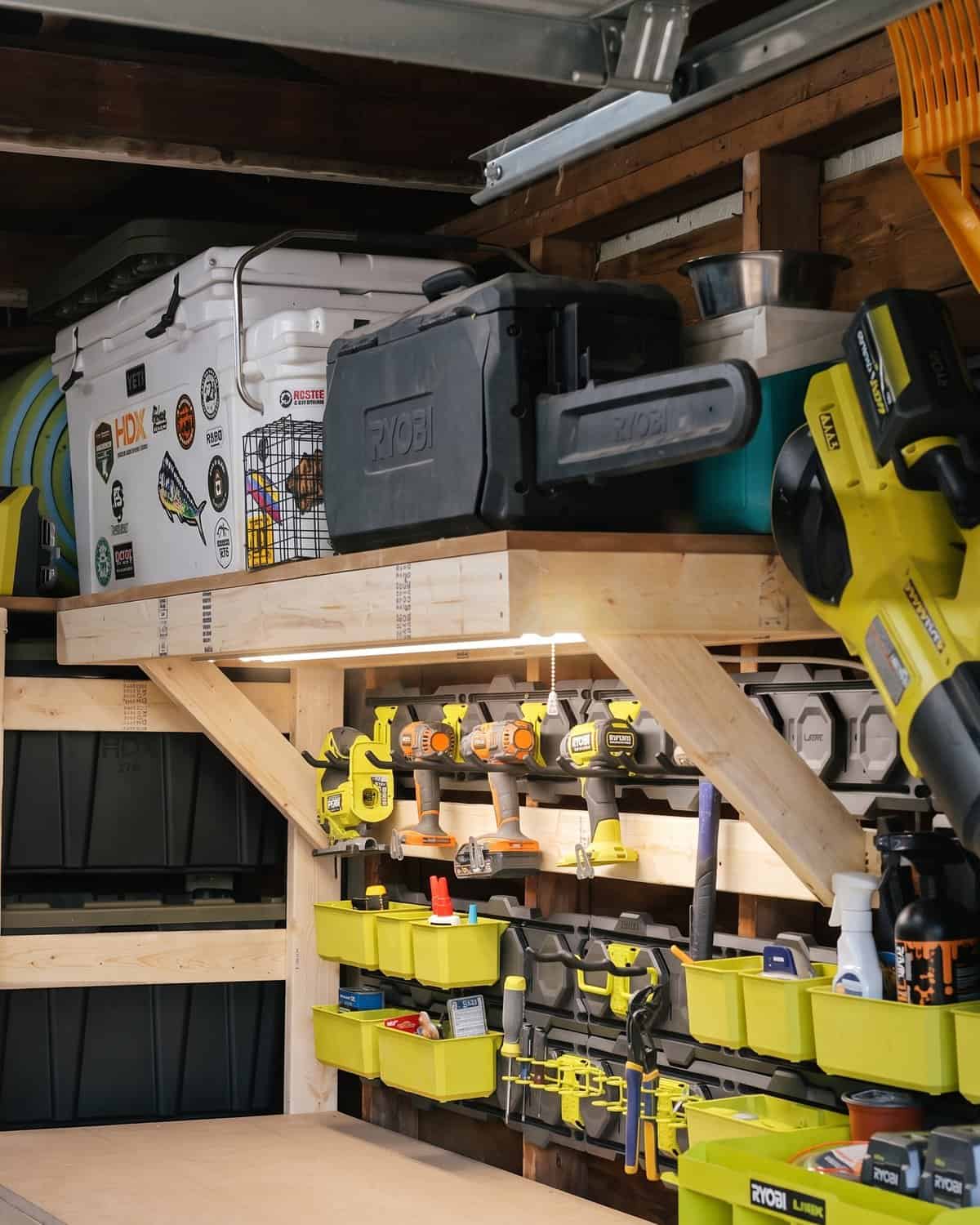 Workbench shelf hung on 2x4 ledgers with an angled 2x4 support at the end, light strip underneath