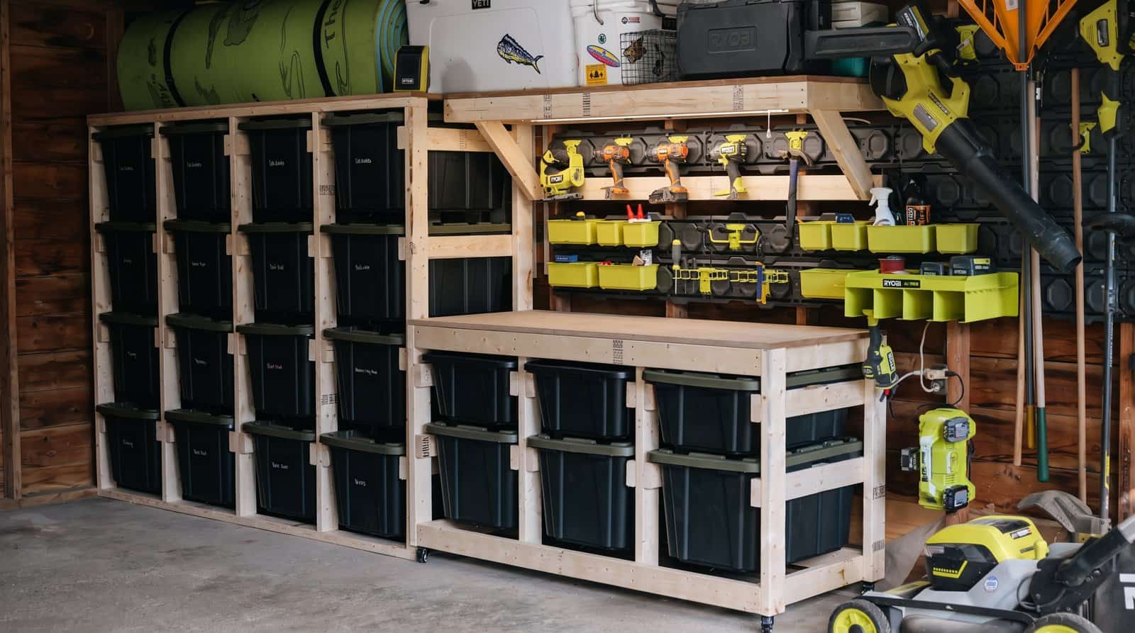 DIY garage storage wall with a 2x4 tote rack, a mobile tote workbench and a shelf above it