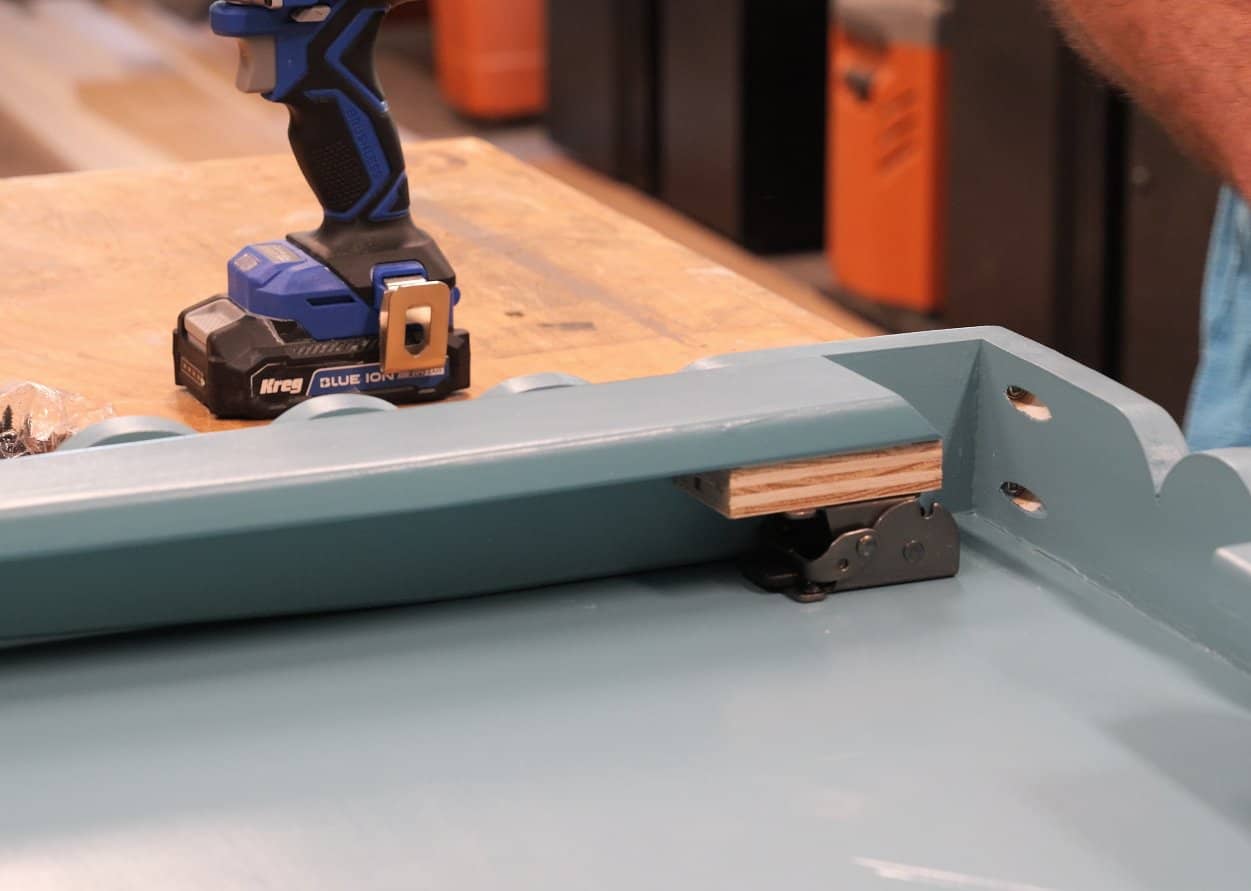 Plywood filler block behind a folding leg bracket on a DIY table