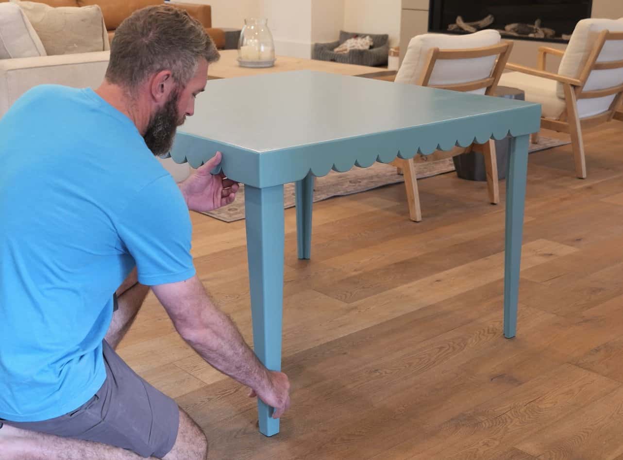 Seating a folding table leg against the apron corner to stop the wobble