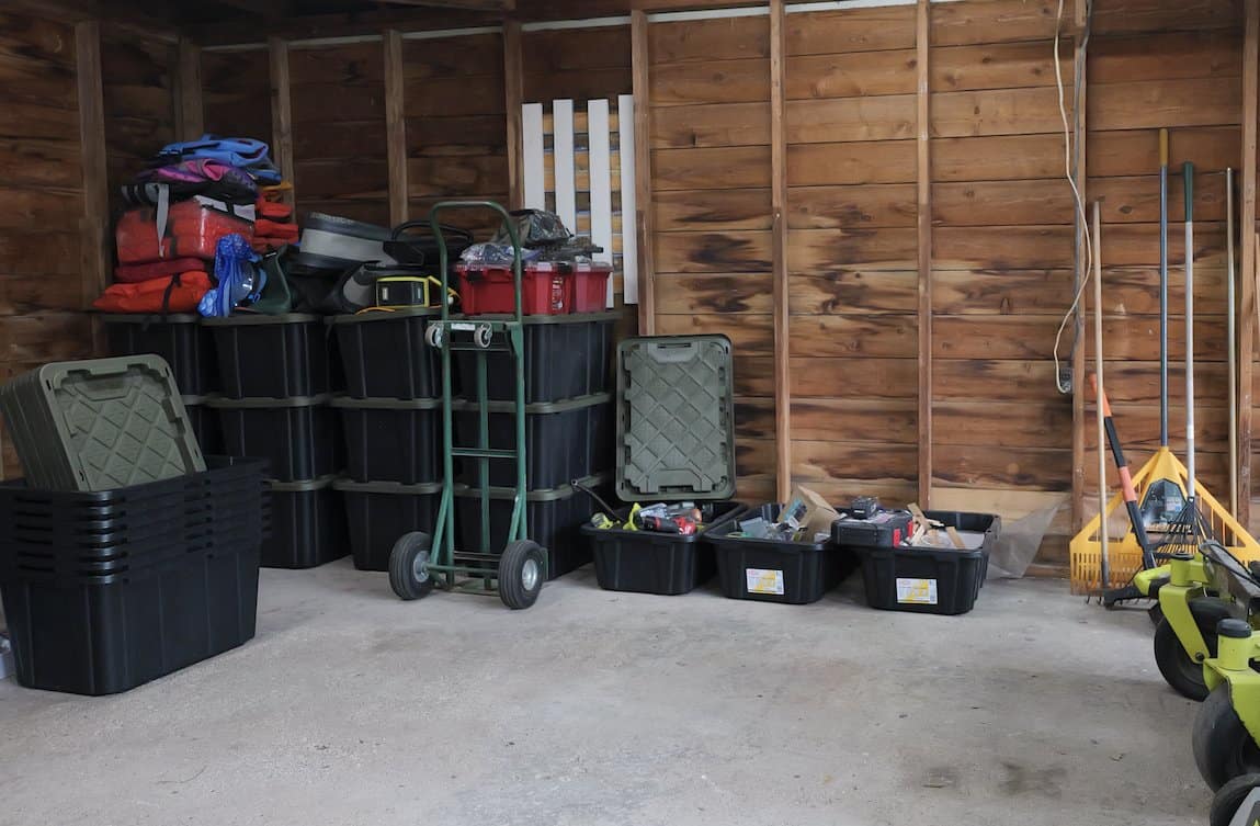 Totes stacked on the garage floor before building the mobile workbench