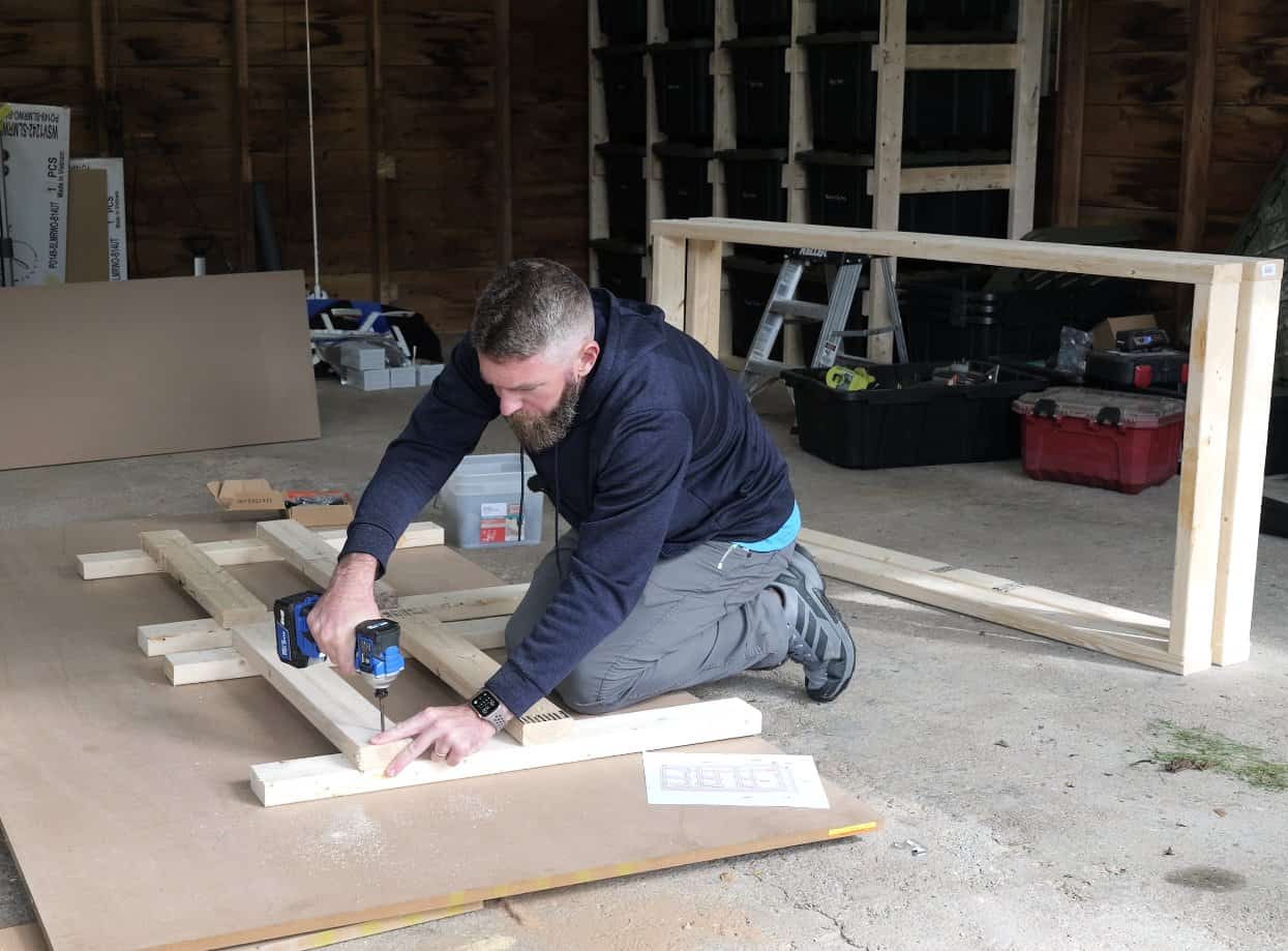 Screwing 2x4 runners onto the legs to build an end ladder