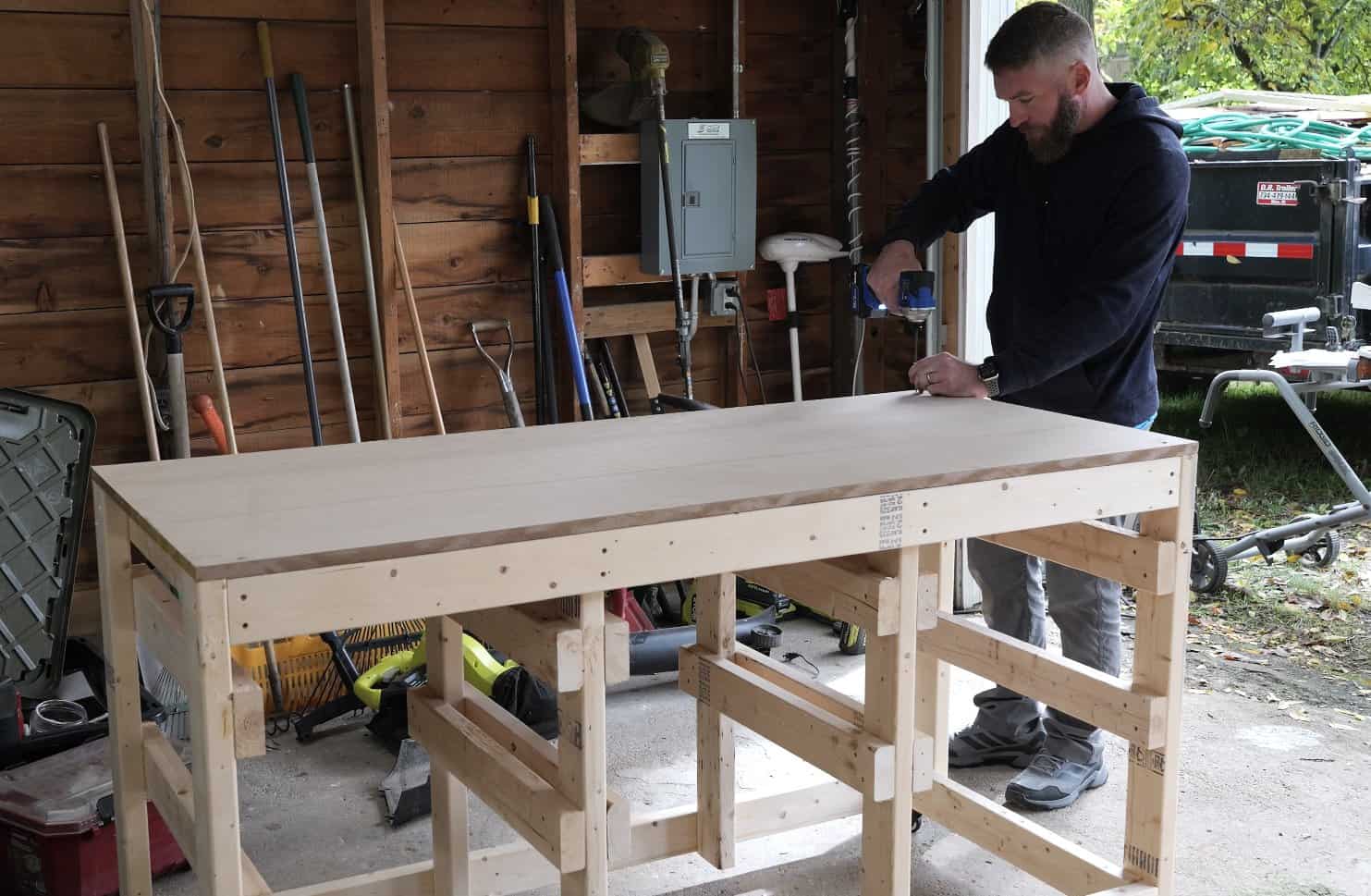 Screwing the plywood top down onto the mobile workbench