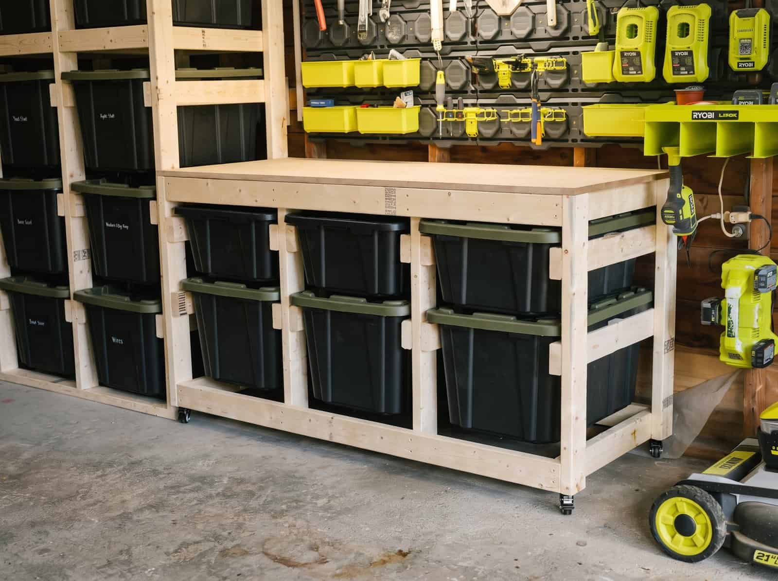 Finished DIY mobile workbench with six totes in a garage