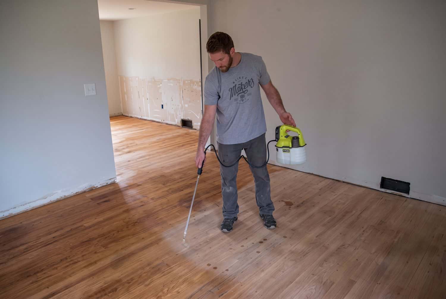 Water popping the sanded oak floor with a sprayer before stain