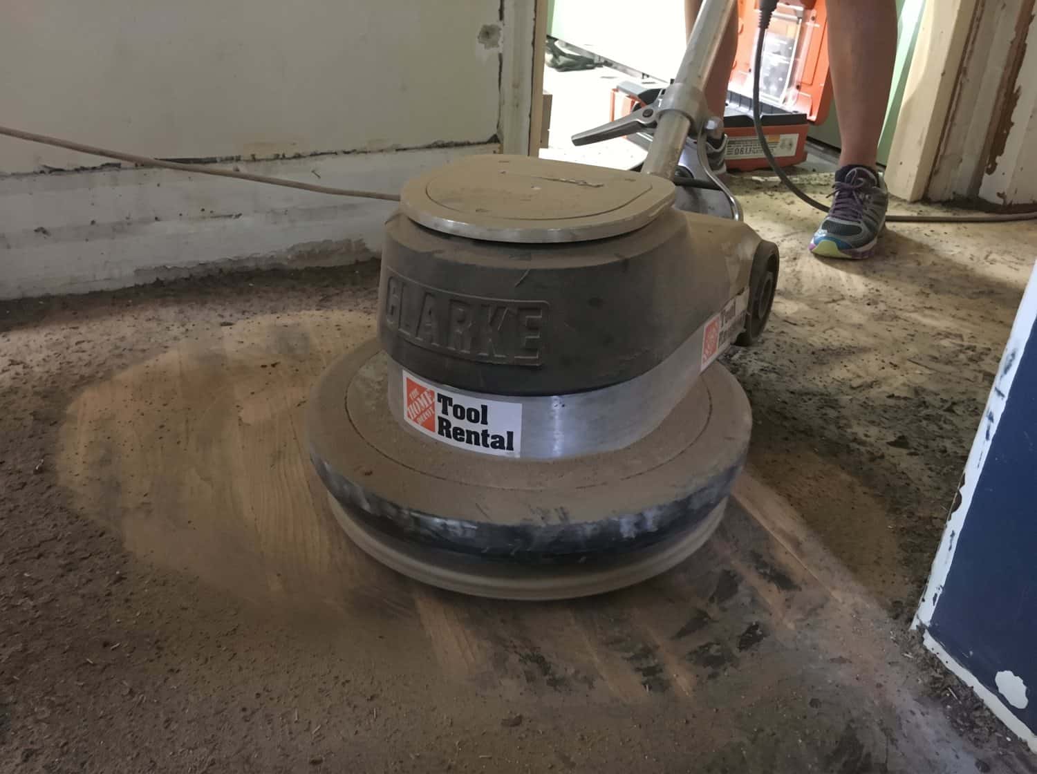 Rented floor polisher with wood tool attachment removing adhesive from hardwood
